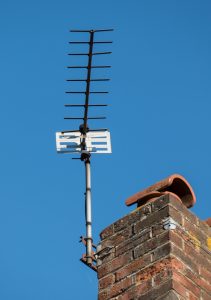 Just a TV aerial bolted to a chimney stack against blue sky